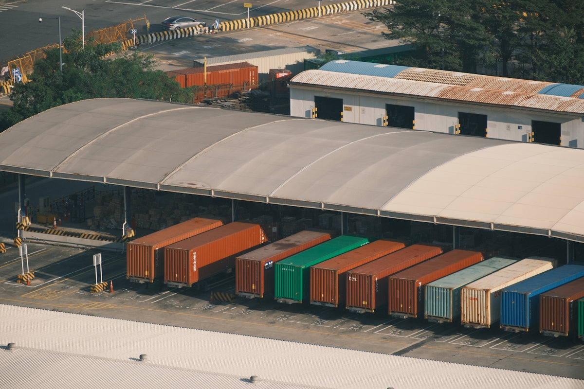 Row of colorful shipping containers under a large awning